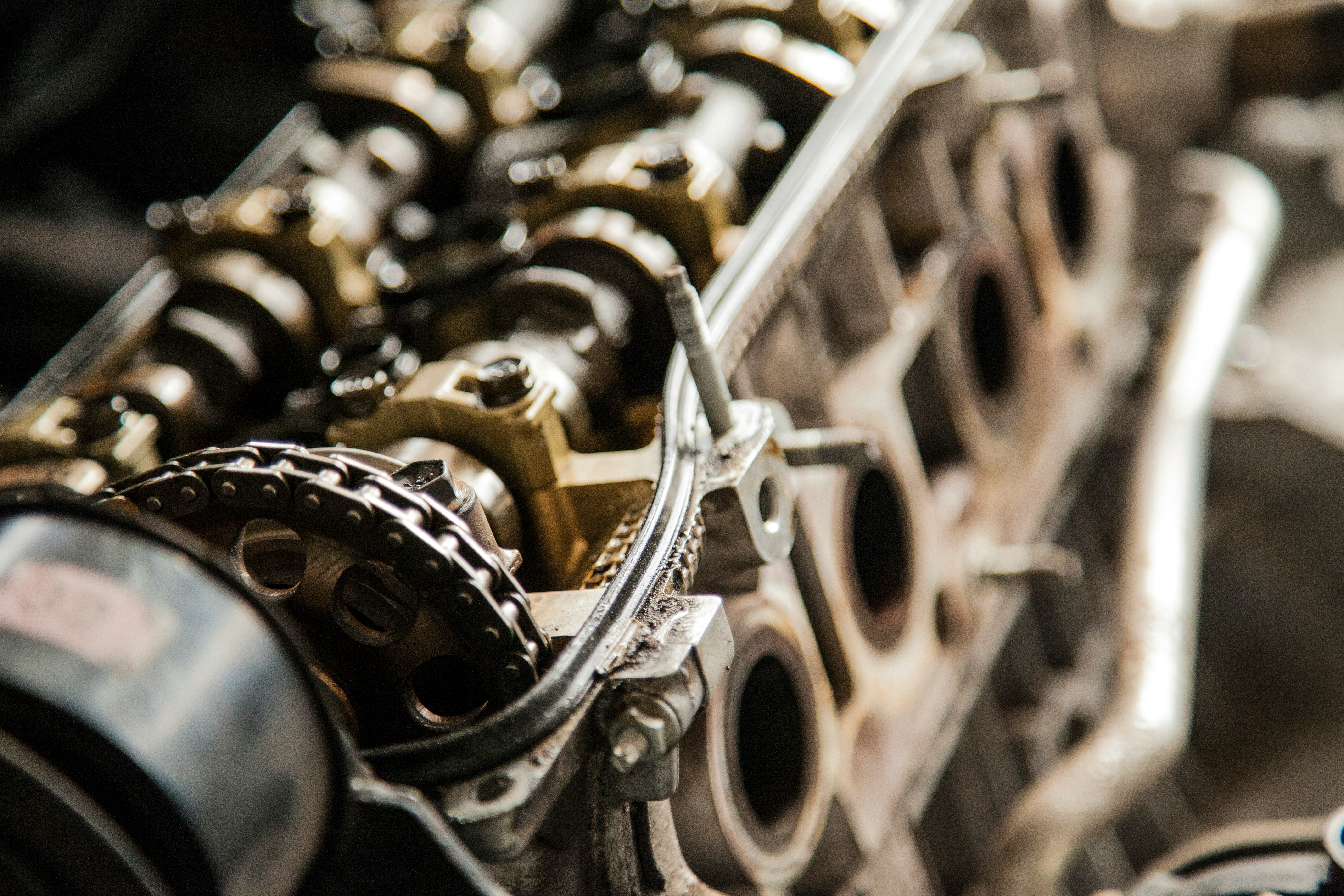 Close-up van een motorblok met distributieketting en nokkenas