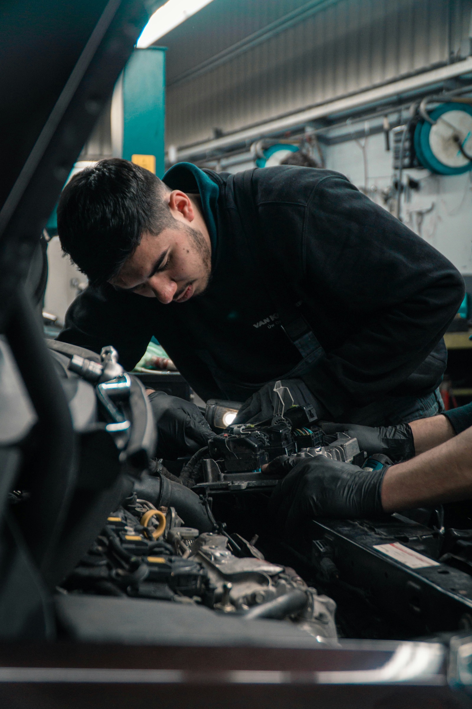 Monteur van Autofix Harderwijk werkt aan de motor van een auto